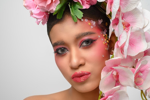 Woman wore pink makeup and beautifully decorated the flowers isolated on white