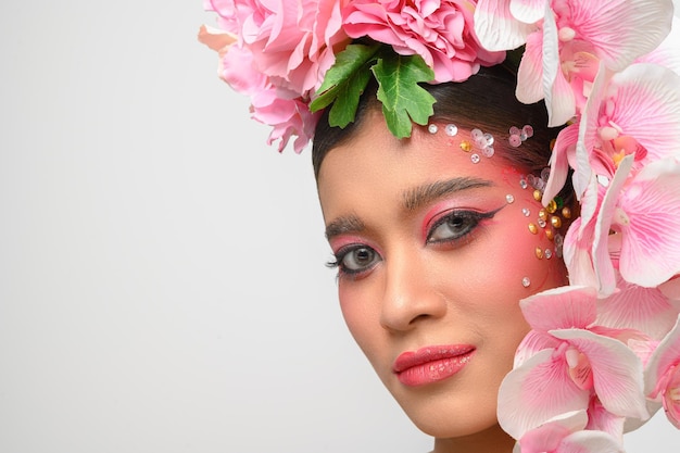 Woman wore pink makeup and beautifully decorated the flowers isolated on white