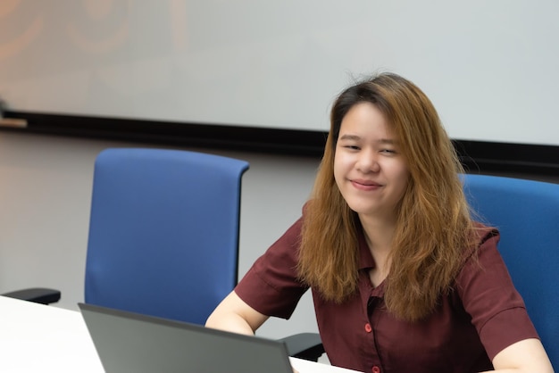 Woman working by laptop in office with happy