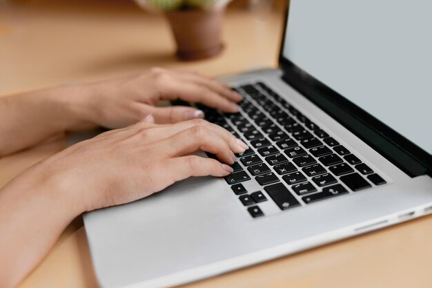 Woman working at home office hand on keyboard close up