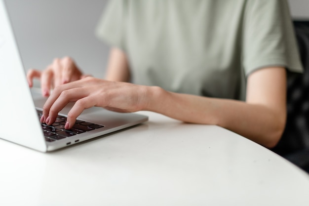 Woman working at home office hand on keyboard close up