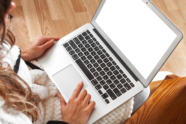 Woman working at home sitting in chair with laptop