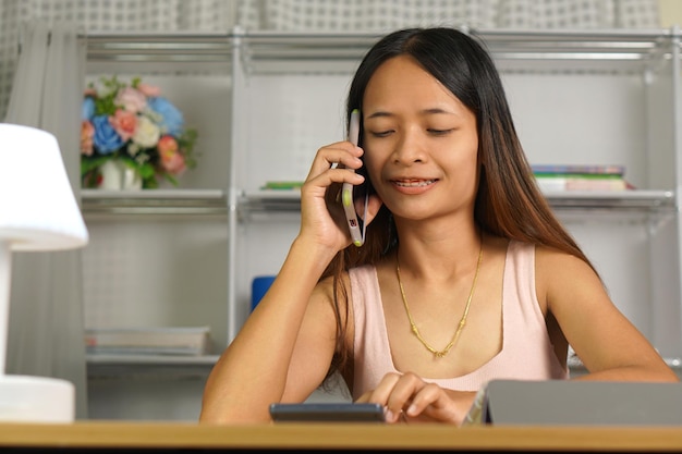 woman working at home Use your phone and computer to communicate with your teammates