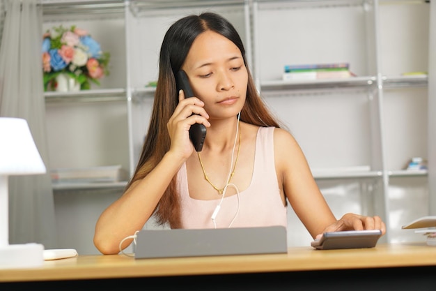 woman working at home Use your phone and computer to communicate with your teammates