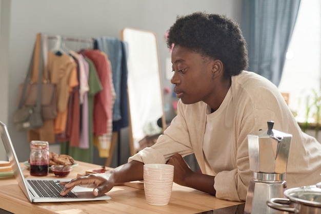 Woman working on laptop during breakfast