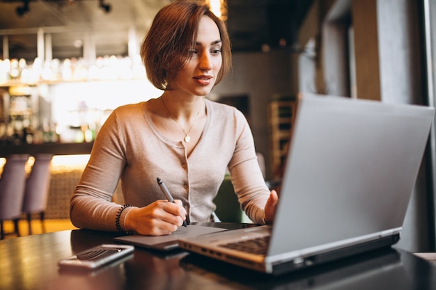 Woman working on laptop in a cafe