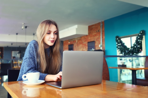 Woman working on laptop in a cafe