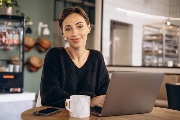 Woman working on laptop in a cafe