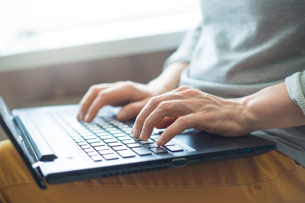 Woman working on a laptop. Close-up of the keyboard and hands. Freelance. 