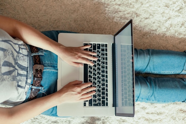 Woman working on a laptop Female using a laptop sitting on floor searching web browsing information