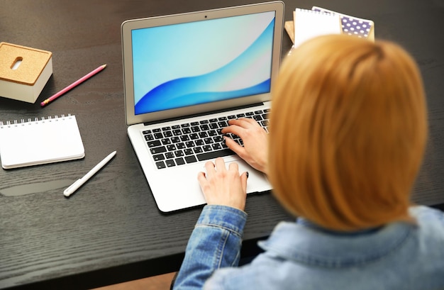 Woman working on a laptop at office desk