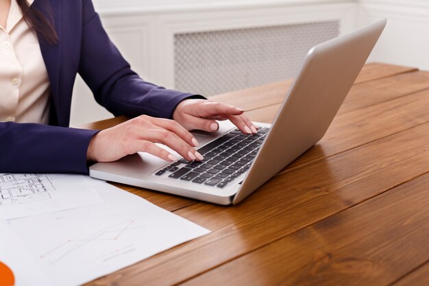 Woman working at office, hand on keyboard close up