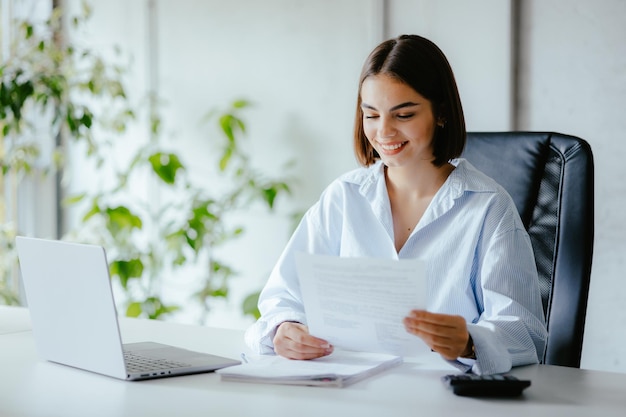 Woman working in the office with different papers and financial information