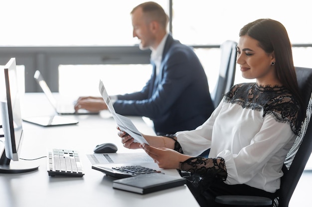 Woman working in the office with documents Happy business lady entrepreneur watching contracts