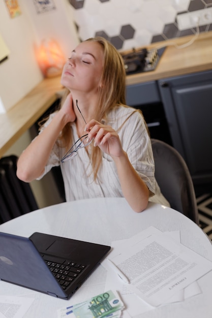 woman working on pc laptop suffering from neck pain, osteochondrosis, muscle spasm