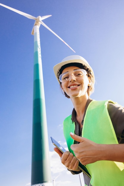 Woman working on tablet controlling functioning of wind turbines