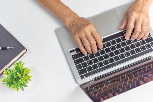 woman working and typing on the keyboard on table at homeTop view