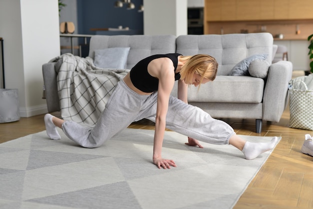 Woman working up forward splits warming up her legs