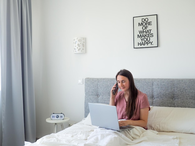 Woman working with laptop on the bed