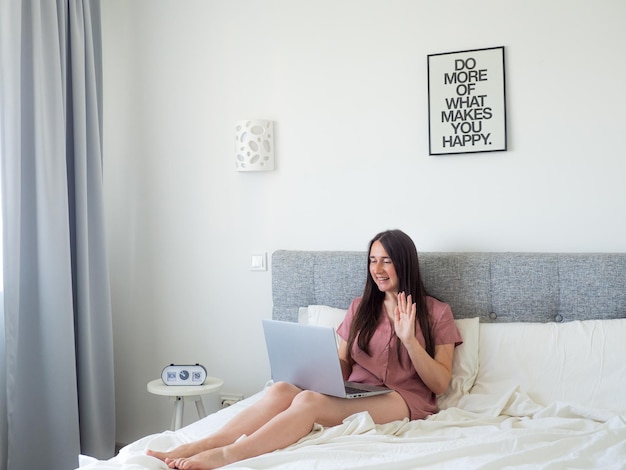 Woman working with laptop on the bed