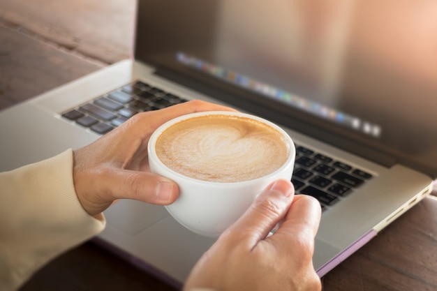 Woman working with laptop and hot coffee