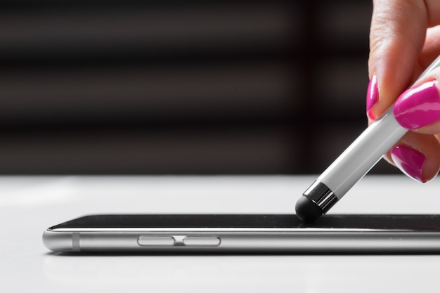 Woman working with pen on smart mobile phone