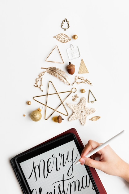 Photo woman writing a christmas card on her tablet