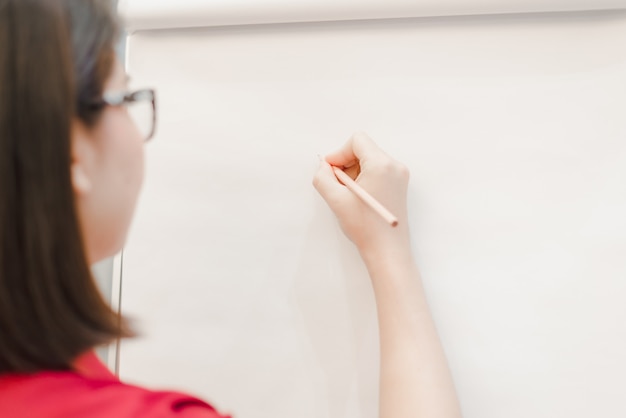 Photo woman writing on flip chart paper