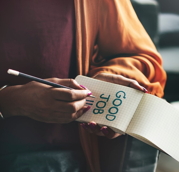 Woman writing Good job on a notepad