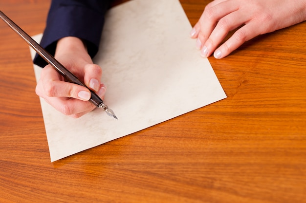 Woman writing a letter with pen and ink