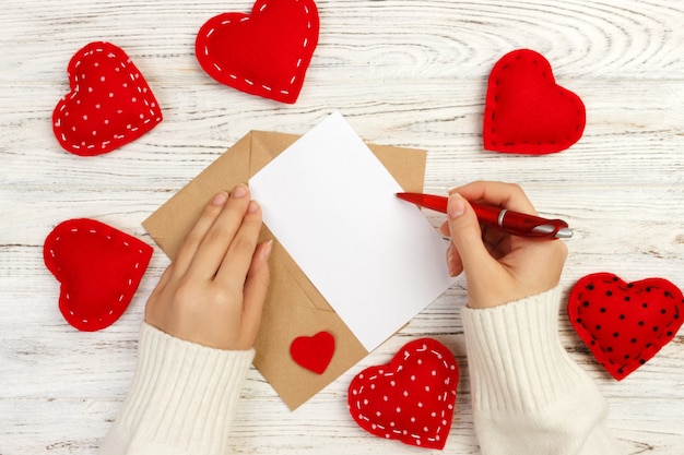 Woman writing love letter on blank greeting card