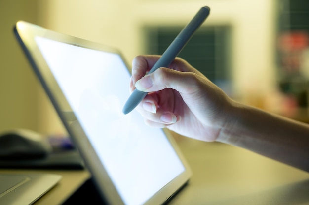 Woman writing on tablet pc