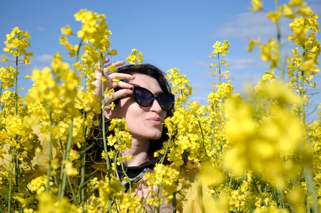 Woman and yellow flowers of rapeseed