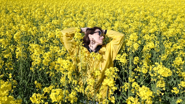 Woman and yellow flowers of rapeseed