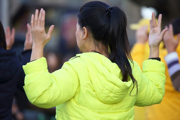 Woman in yellow jacket with hands up