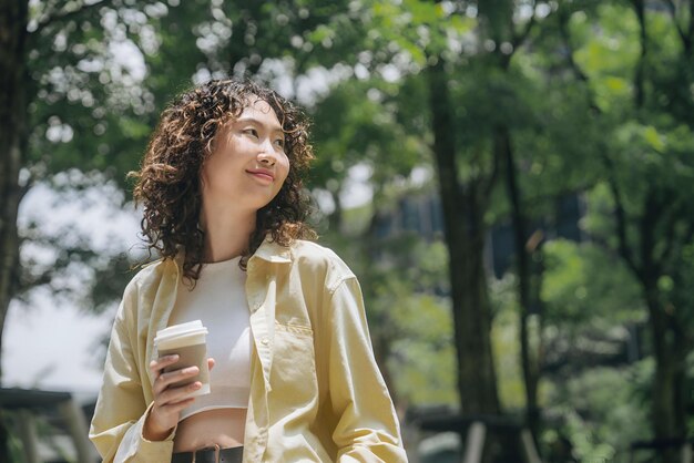 a woman in a yellow shirt is holding a cup of coffee