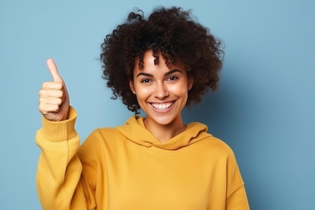 A woman in a yellow sweater gives a thumbs up.