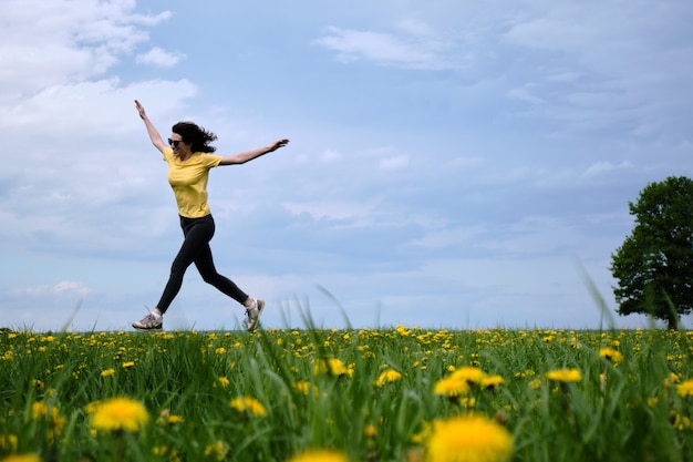 Woman in a yellow t-shirt moves across the field with flowers