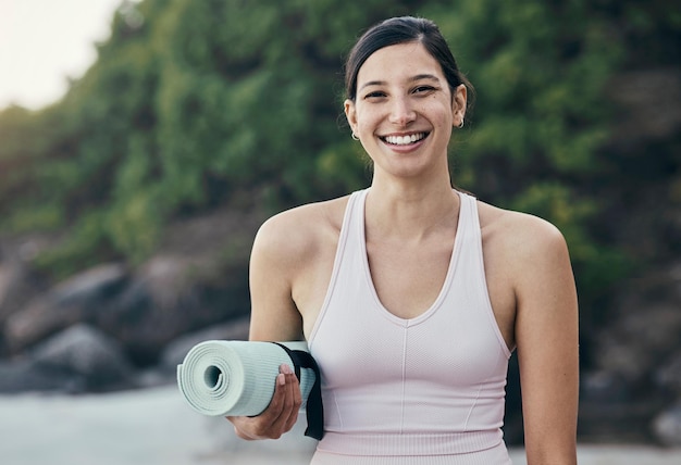 Woman yoga and fitness portrait in nature while outdoor for exercise training and workout Happy model person with mat for zen peace and holistic time for health and wellness with beach pilates