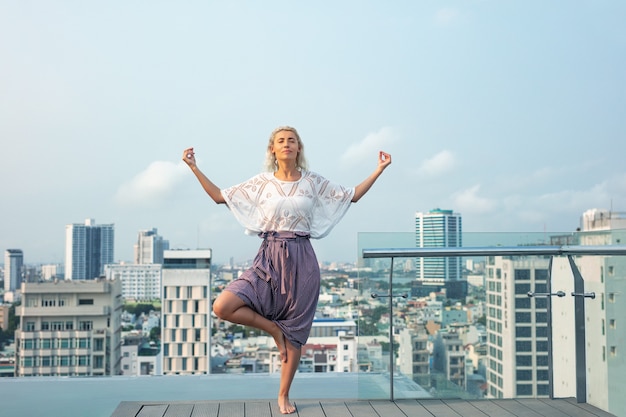 Woman young beautiful on the roof of the hotel by the pool with a view of the city