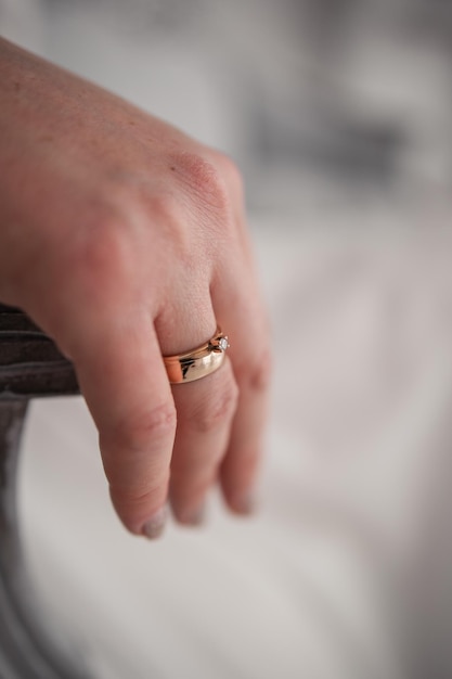 Woman39s hand on a chair with a golden ring at the bride