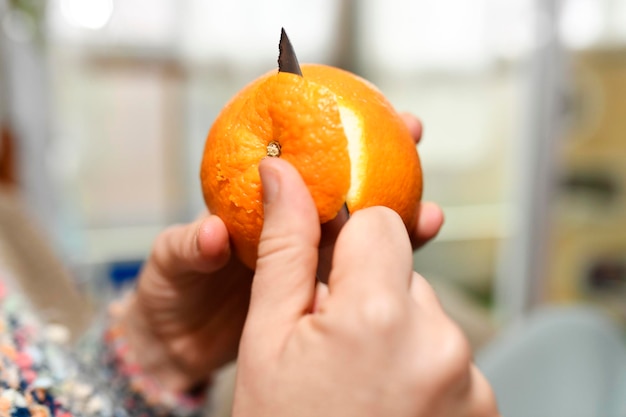 Woman39s hand peeling an orange