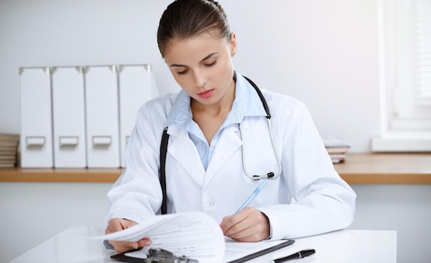 Womandoctor sitting and working at clinic office Portrait of female physician Medicine concept