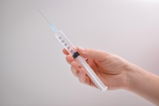 A womannurse scientist hand hold a plastic syringedisposable syringe with liquid