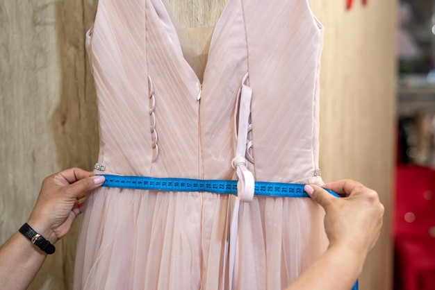 Womans hand chooses an evening dress in a shop