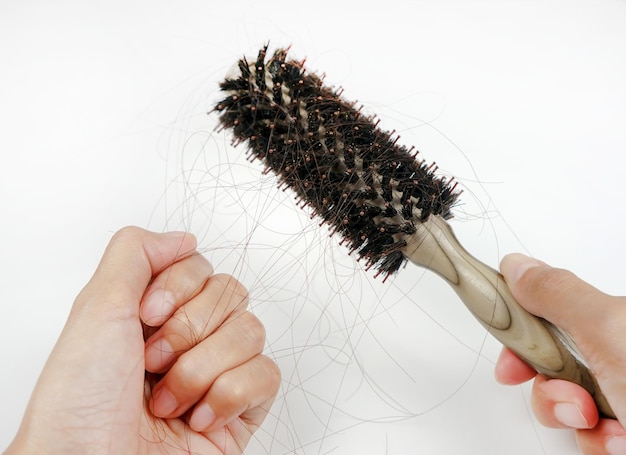 A womans hand grabs the missing hair on the brush isolated on white background