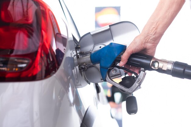 Photo a womans hand holding the petrol pump refueling her car at a selfservice gas station