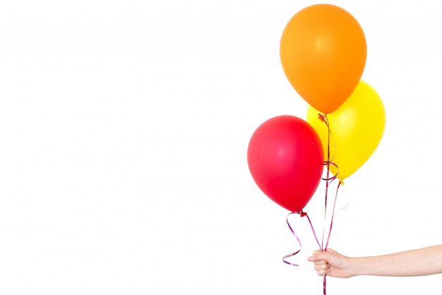 Womans hand holds balloons in a white background