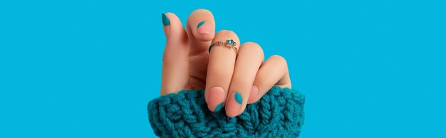 Womans hand with blue manicure trendy winter autumn nail design