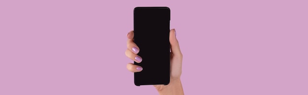 Womans hand with lavender manicure holding smartphone with blank screen